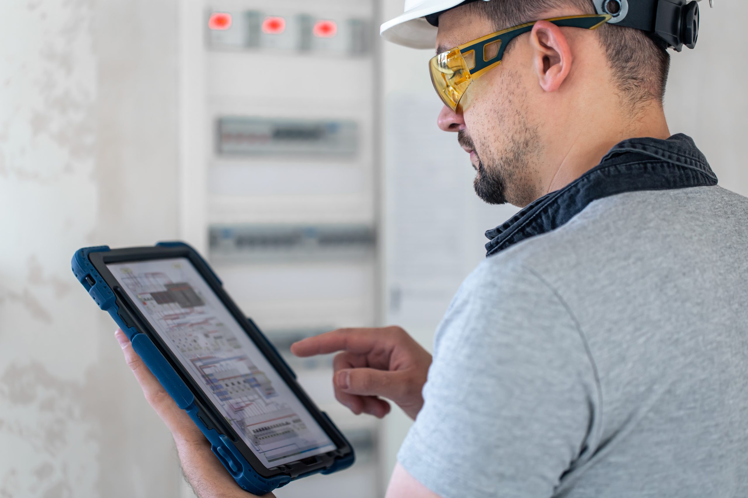 Technician inspecting an electrical switchboard during an NSPIRE property assessment